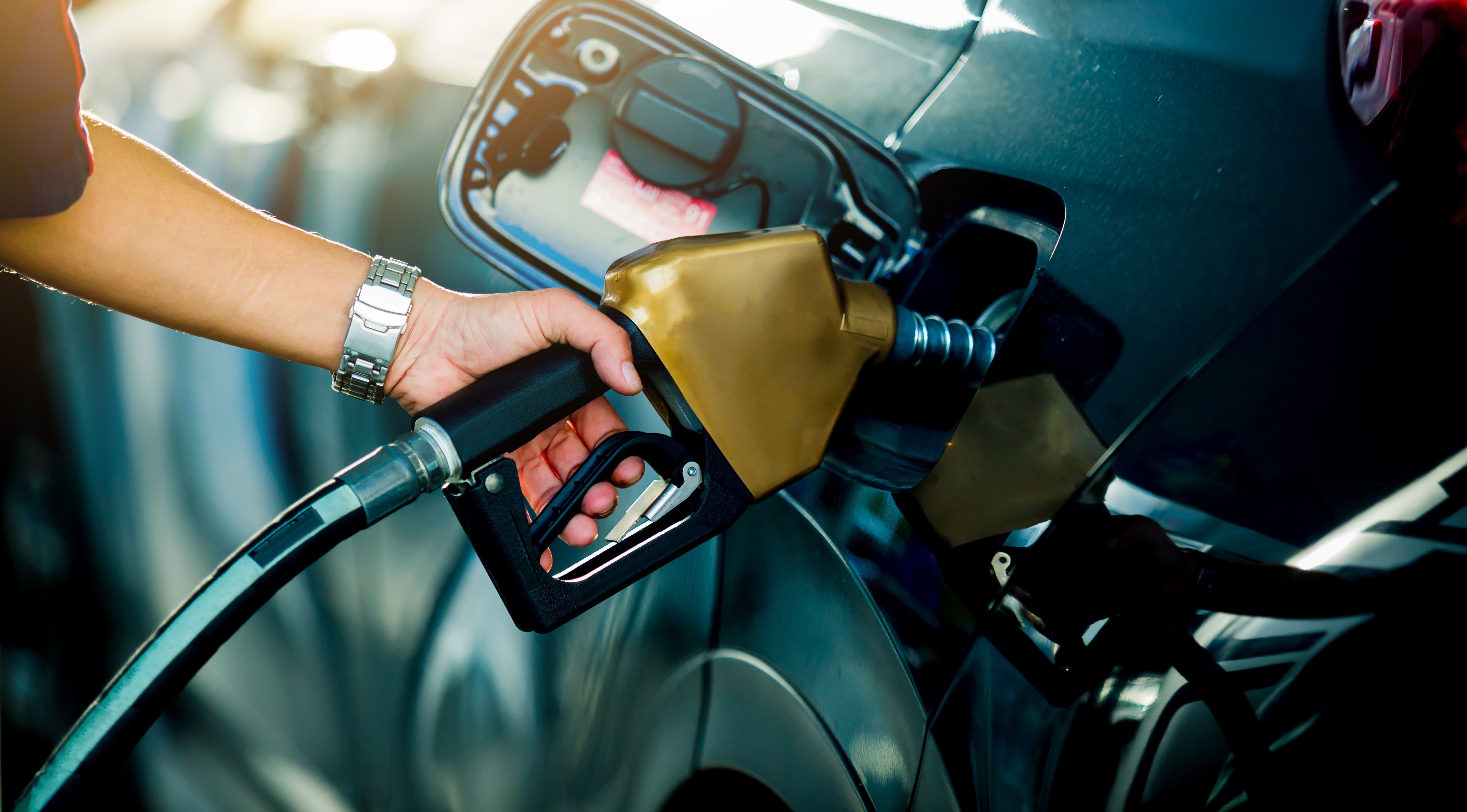 women putting fuel in her car
