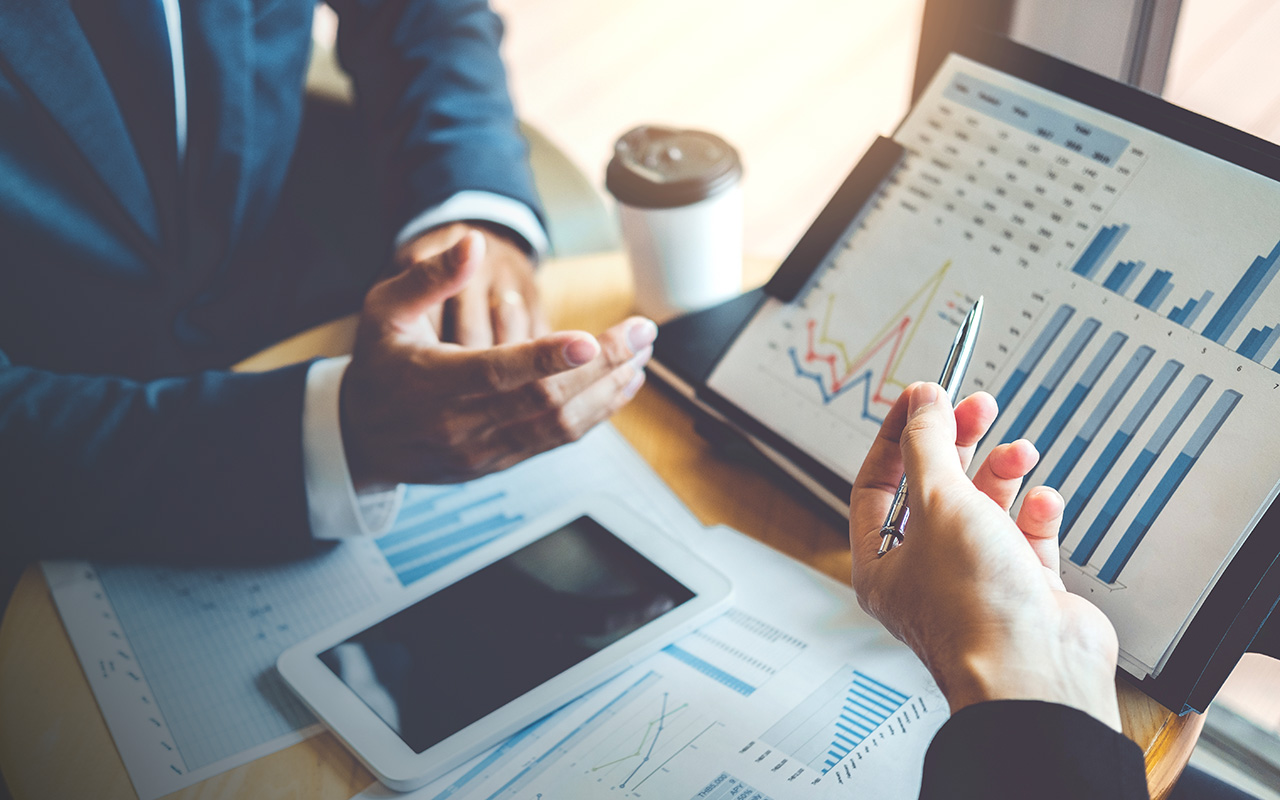 man in suit discussing a chart in office