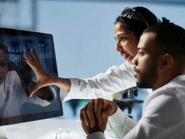 coworkers looking at a graph on a monitor
