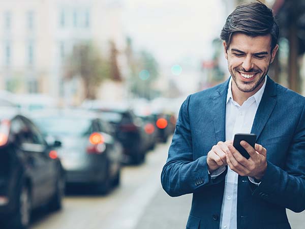 Guy looking at his phone smiling 