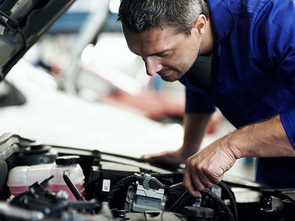 mechanic looking at a car engine