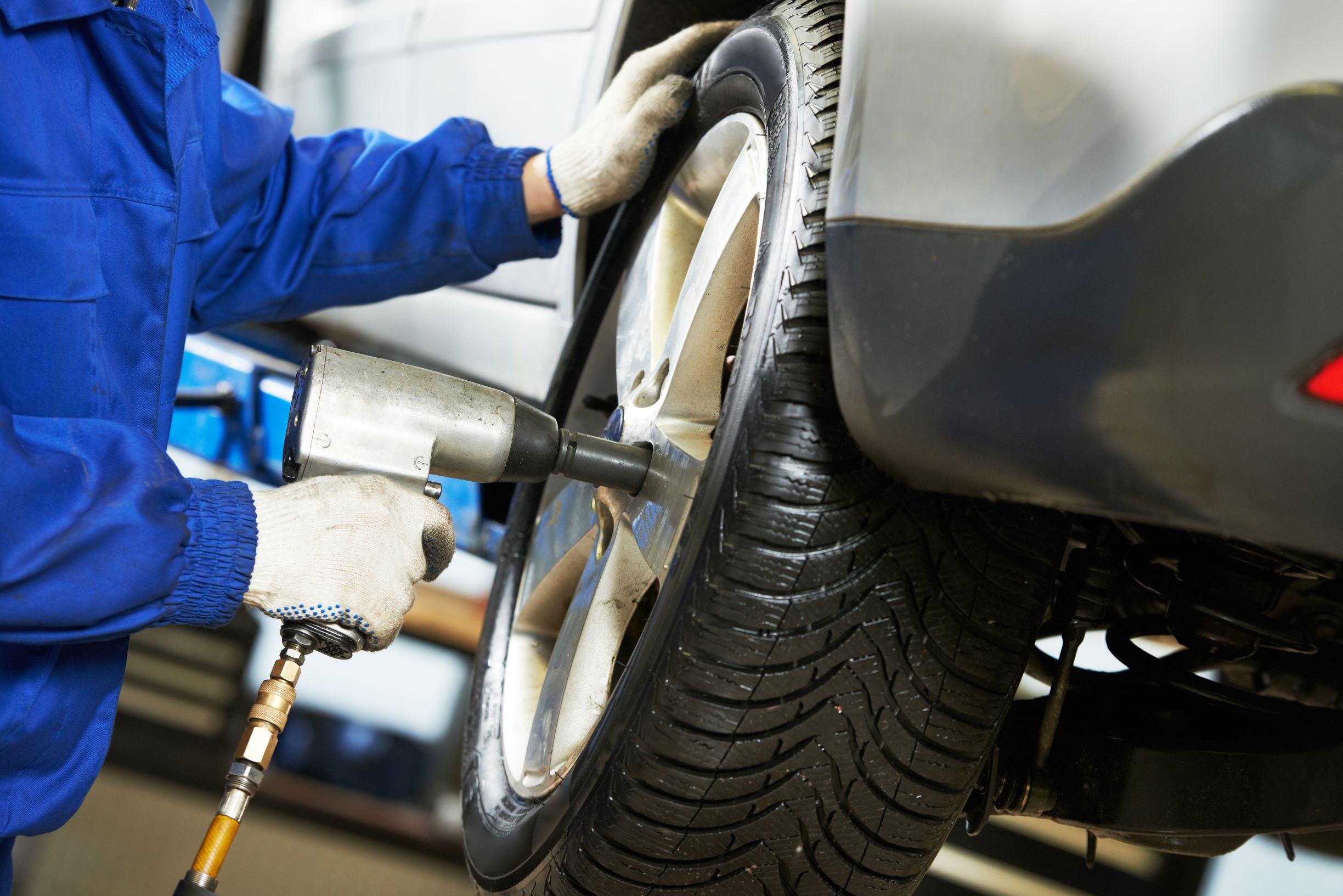 A mechanic removing a tyre from a car