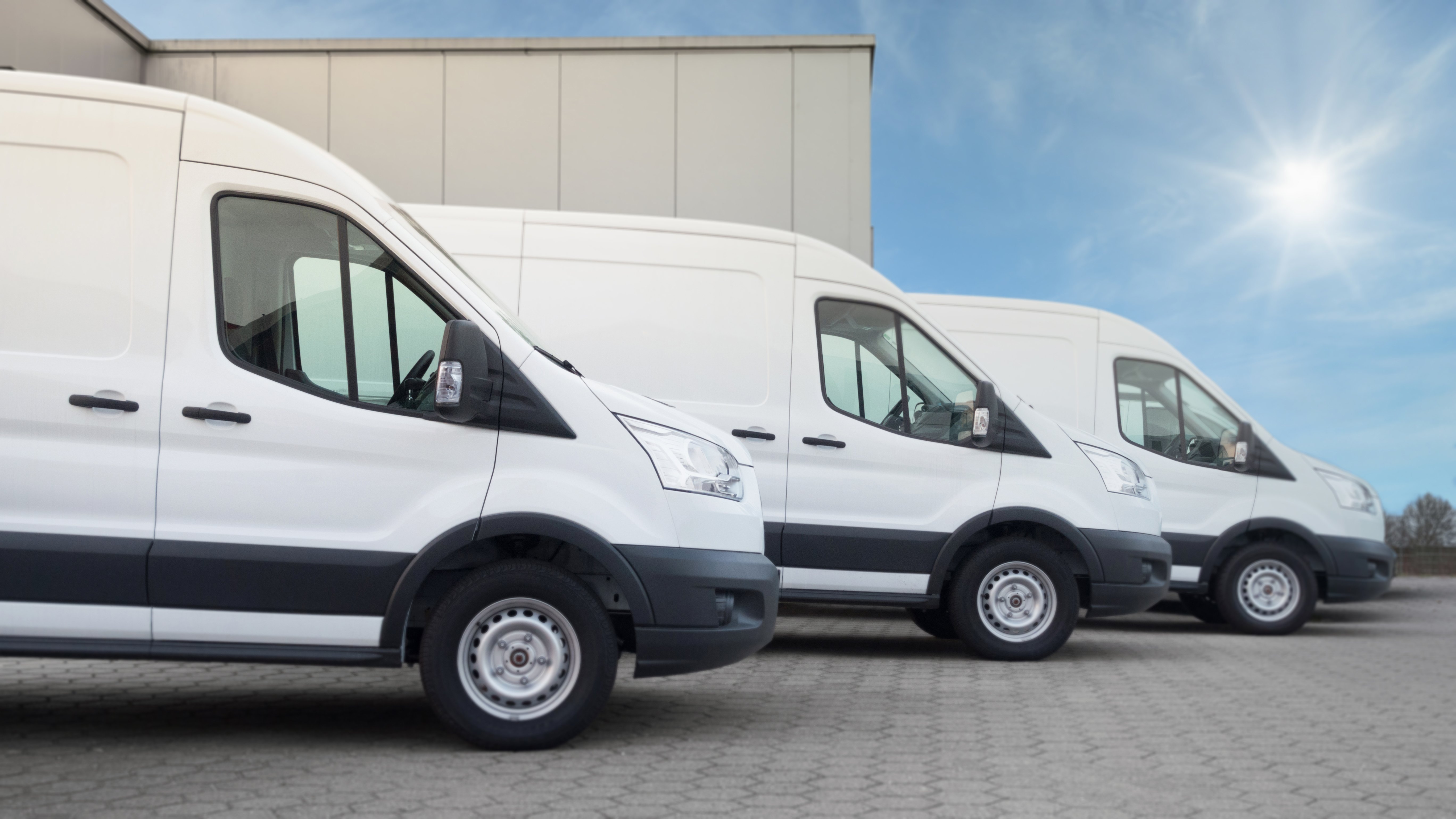 three white vans parked side by side
