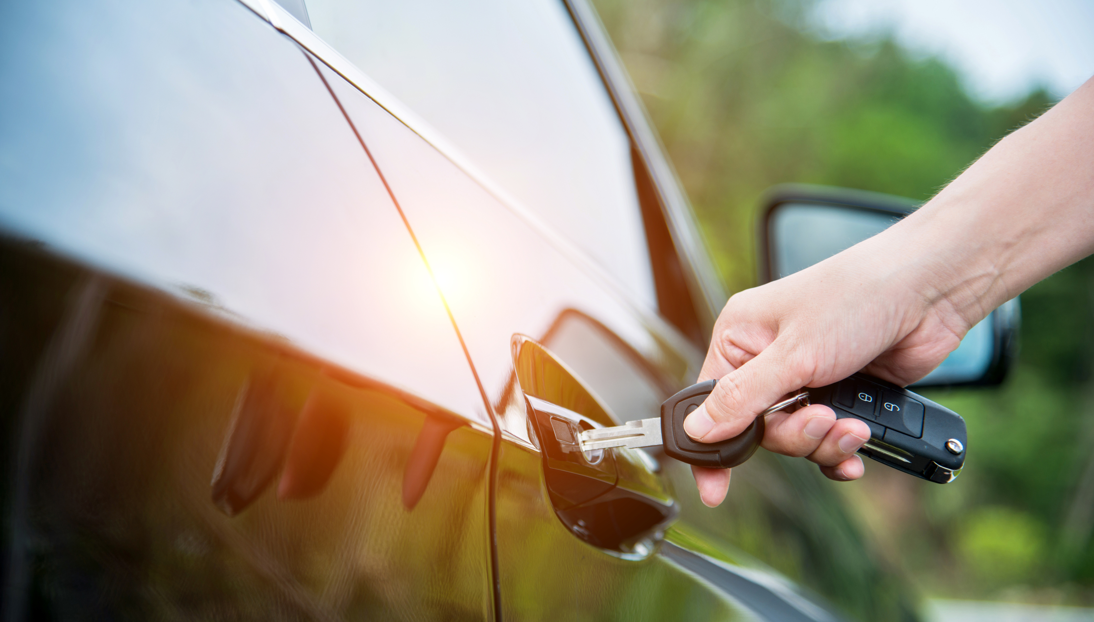 a person opening a car door with their key