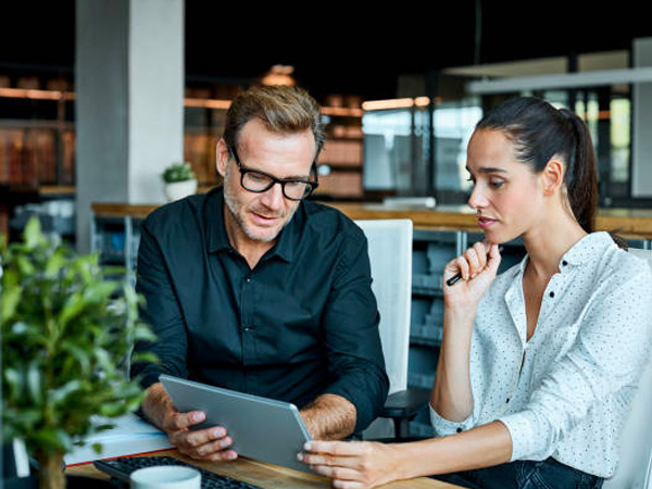a man and a woman looking at a tablet together