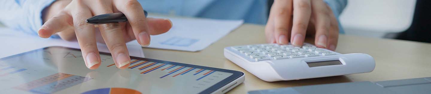 a women looking at graphs and using a calculator
