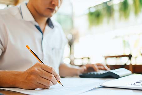 a guy writing with a pencil in a book