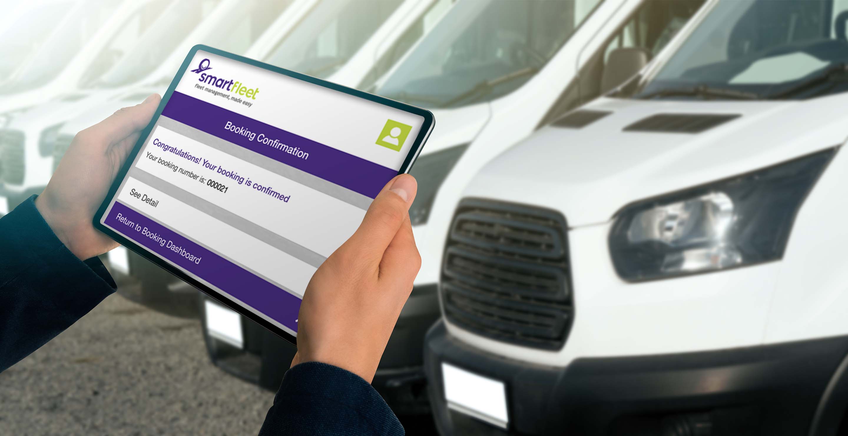 a guys hands looking at an ipad screen in front of a fleet of vans