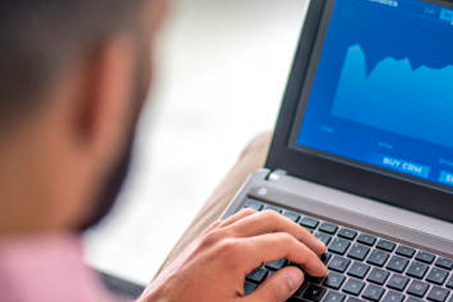 a man looking at his laptop at a graph