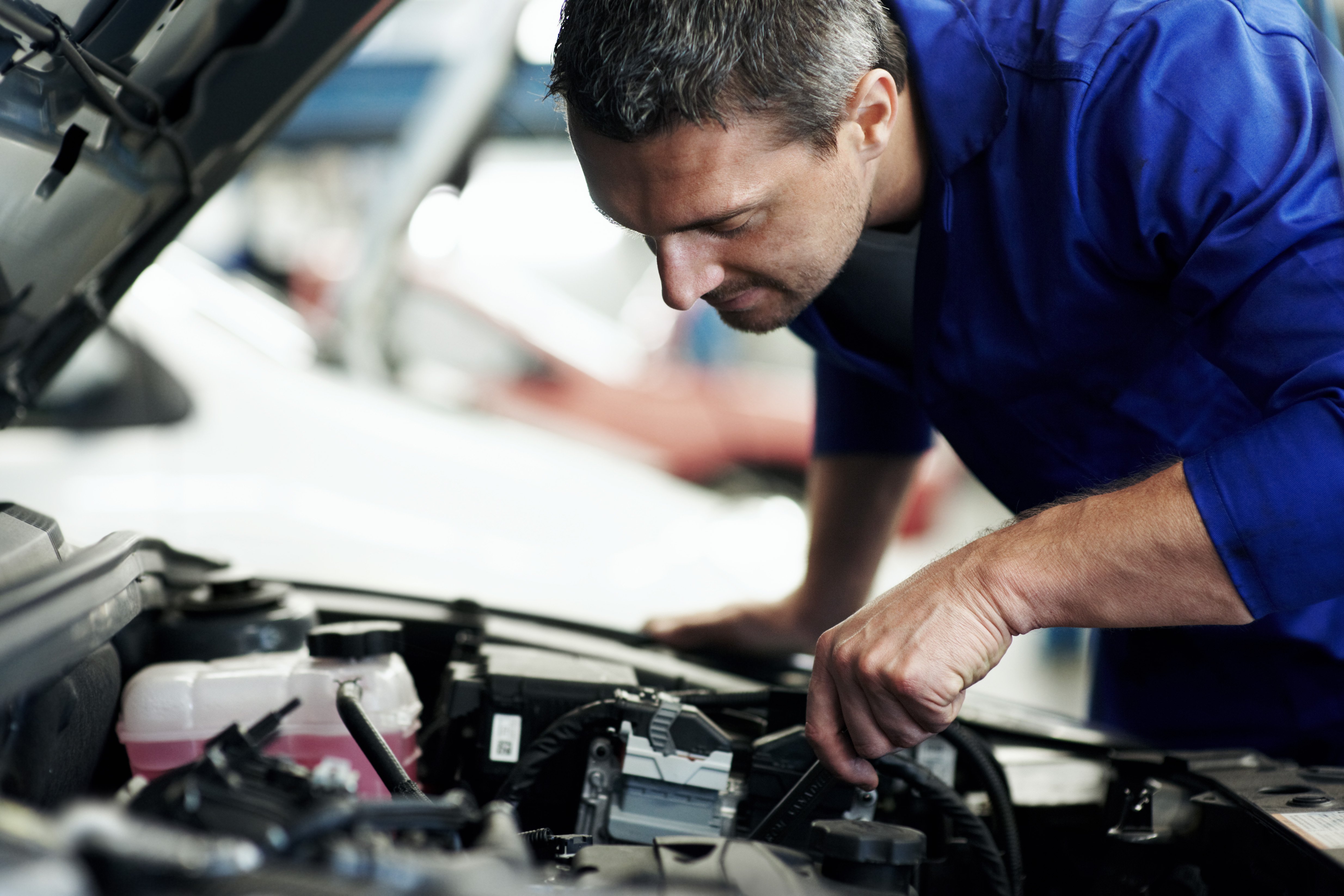 Mechanic looking into a car engine