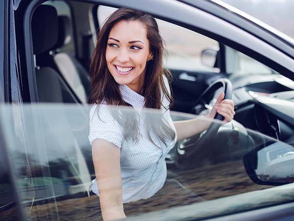 Women getting in her car smiling 