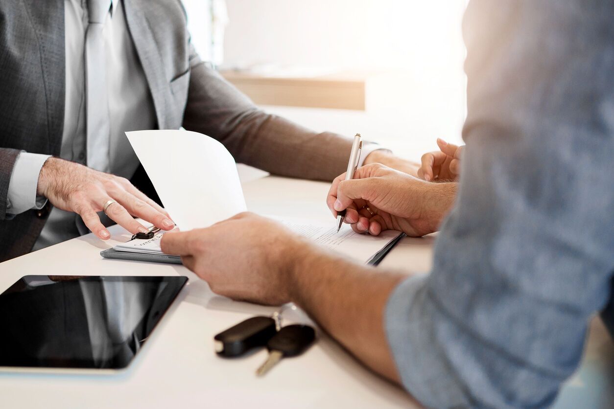 two business people signing documents